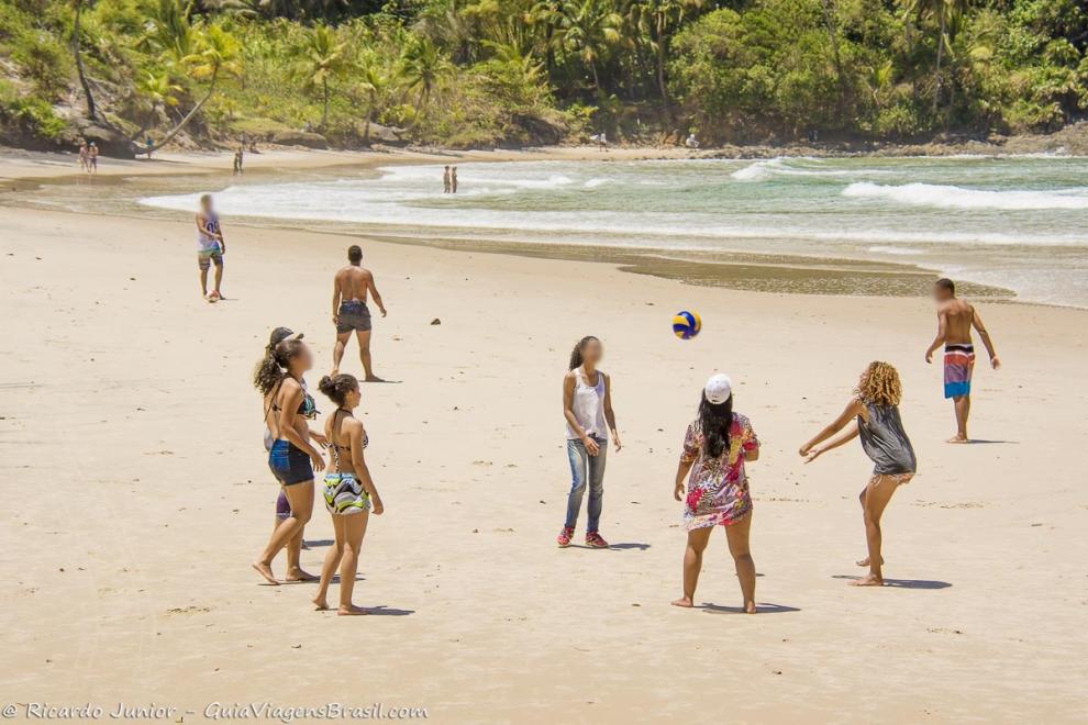 Imagem de amigas jogando volei na praia.